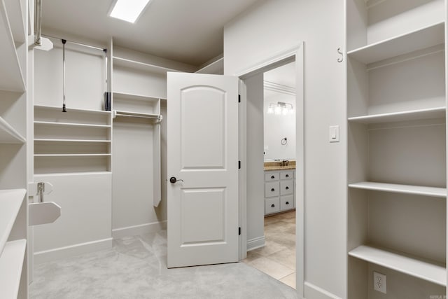 spacious closet featuring light colored carpet