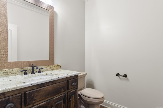 bathroom featuring vanity, toilet, and ornamental molding