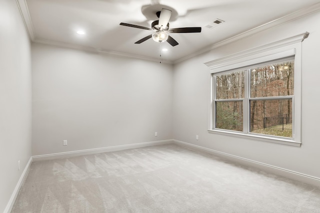 empty room featuring ceiling fan, light colored carpet, and ornamental molding