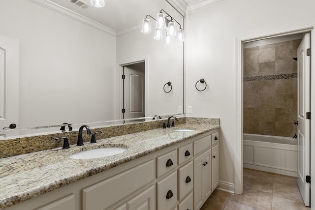 bathroom featuring tile patterned floors, crown molding, vanity, and tiled shower / bath