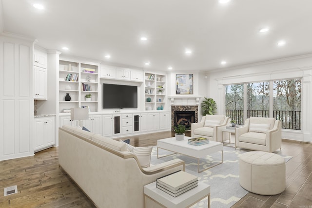 living room with hardwood / wood-style flooring, a premium fireplace, and ornamental molding