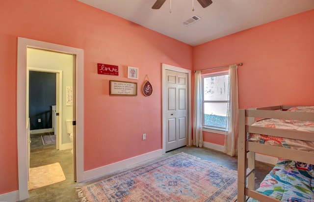 bedroom with ceiling fan, concrete flooring, and a closet