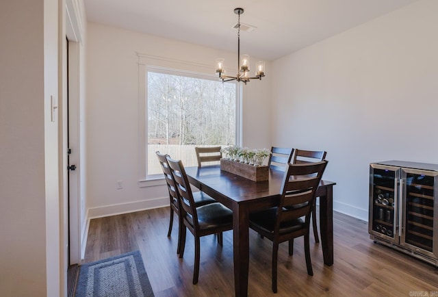 dining space featuring dark hardwood / wood-style flooring, an inviting chandelier, wine cooler, and plenty of natural light