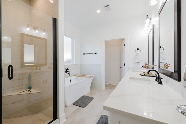 bathroom with vanity and separate shower and tub