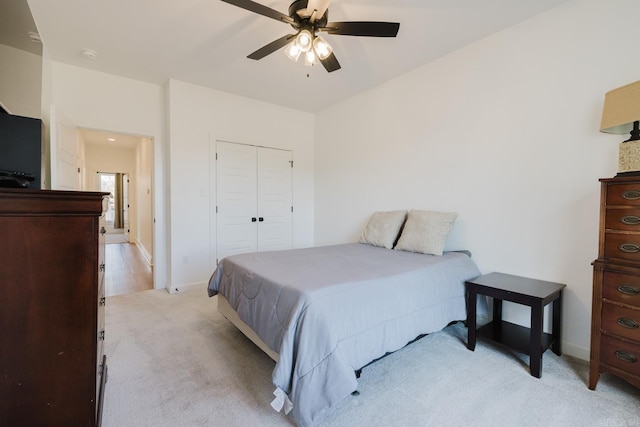 carpeted bedroom with ceiling fan and a closet