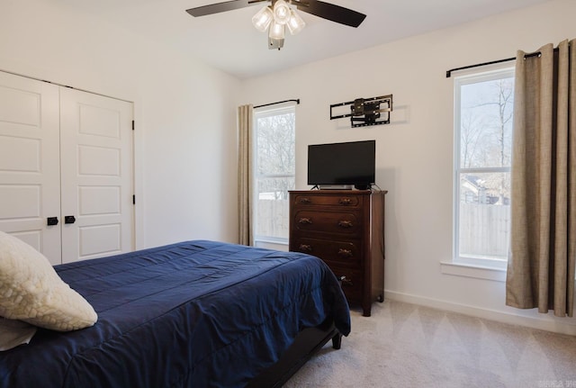 carpeted bedroom featuring ceiling fan and a closet