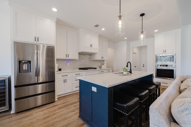 kitchen featuring white cabinetry, sink, an island with sink, and stainless steel appliances