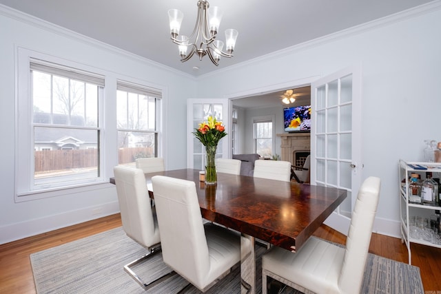 dining area with a healthy amount of sunlight, wood-type flooring, and crown molding