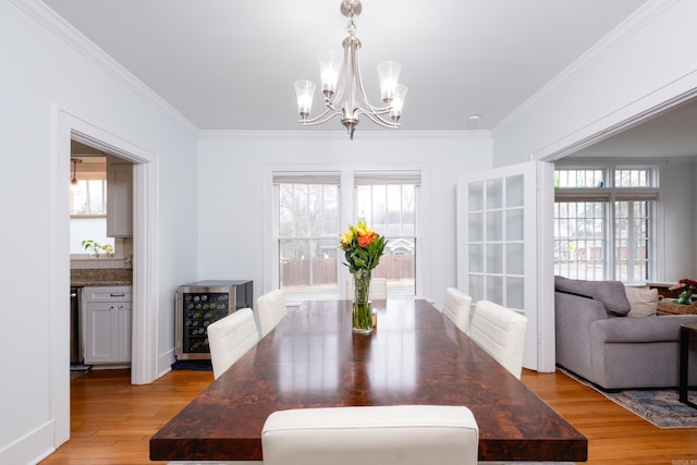 dining space with light hardwood / wood-style floors, a healthy amount of sunlight, and wine cooler