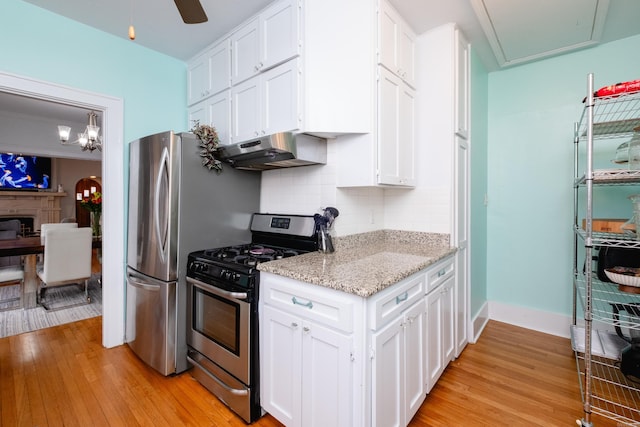 kitchen with white cabinets, light hardwood / wood-style flooring, stainless steel appliances, and tasteful backsplash