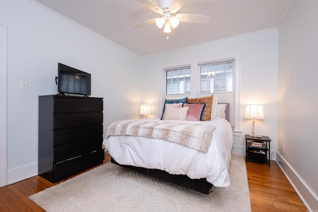 bedroom featuring ceiling fan, hardwood / wood-style floors, and crown molding