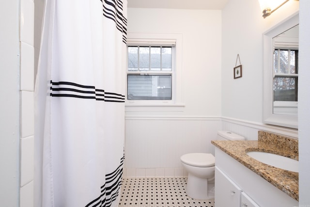 bathroom featuring toilet, a healthy amount of sunlight, and vanity