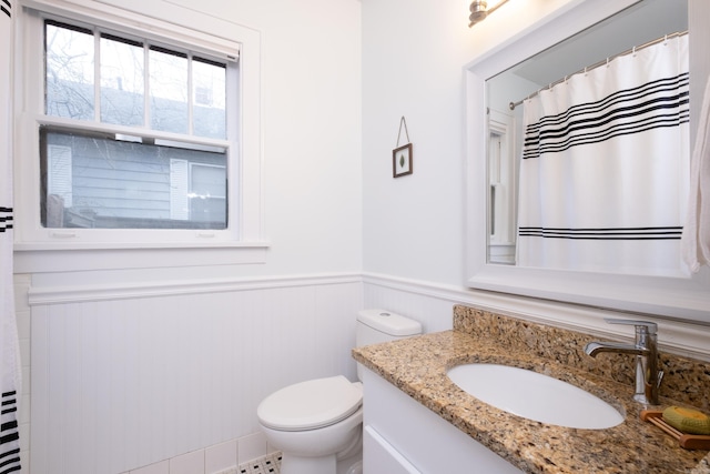 bathroom with toilet, vanity, and a shower with shower curtain