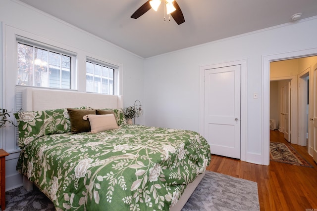 bedroom with ceiling fan, hardwood / wood-style flooring, and ornamental molding