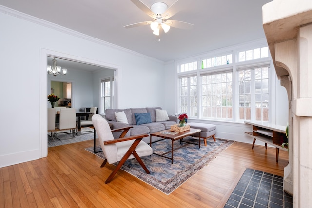 living room featuring crown molding, ceiling fan with notable chandelier, and hardwood / wood-style floors