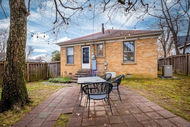 rear view of house with cooling unit, a yard, and a patio