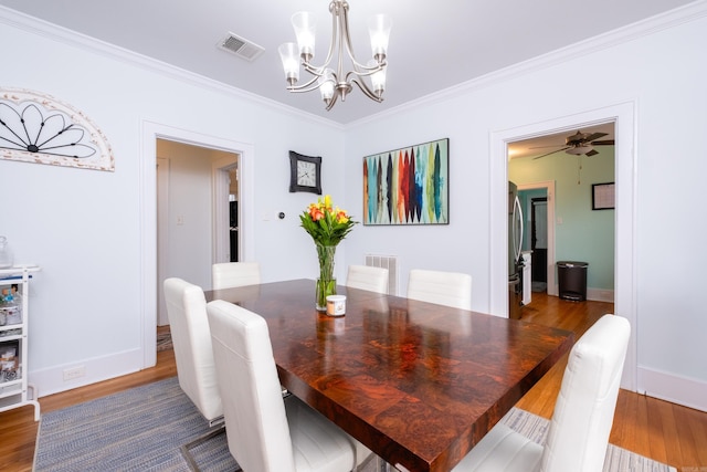 dining room featuring wood-type flooring, ceiling fan with notable chandelier, and crown molding