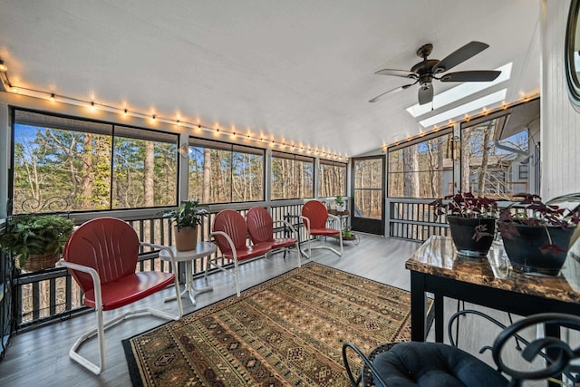 sunroom / solarium with lofted ceiling with skylight and ceiling fan