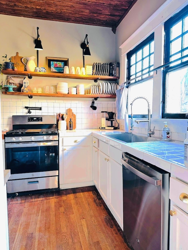 kitchen featuring tile counters, white cabinetry, stainless steel appliances, and tasteful backsplash