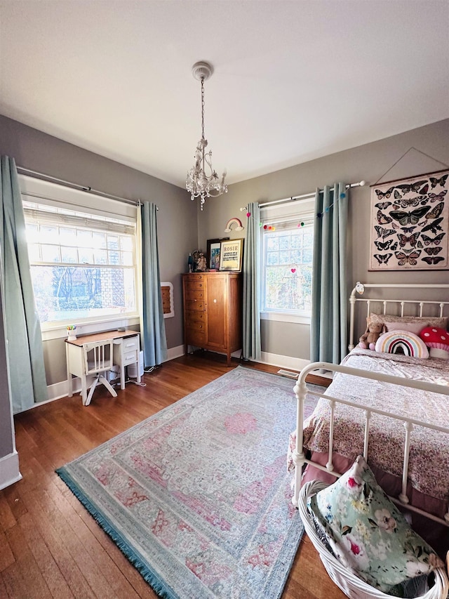 bedroom with a chandelier and dark hardwood / wood-style floors