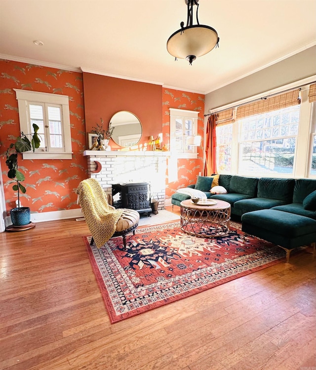 living room with crown molding, hardwood / wood-style floors, and a brick fireplace