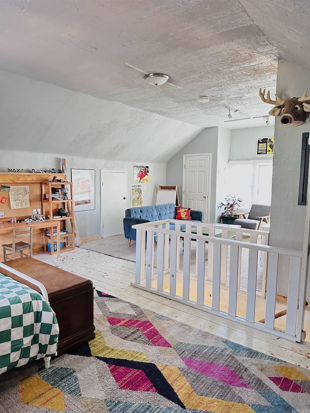 bedroom with a textured ceiling and lofted ceiling