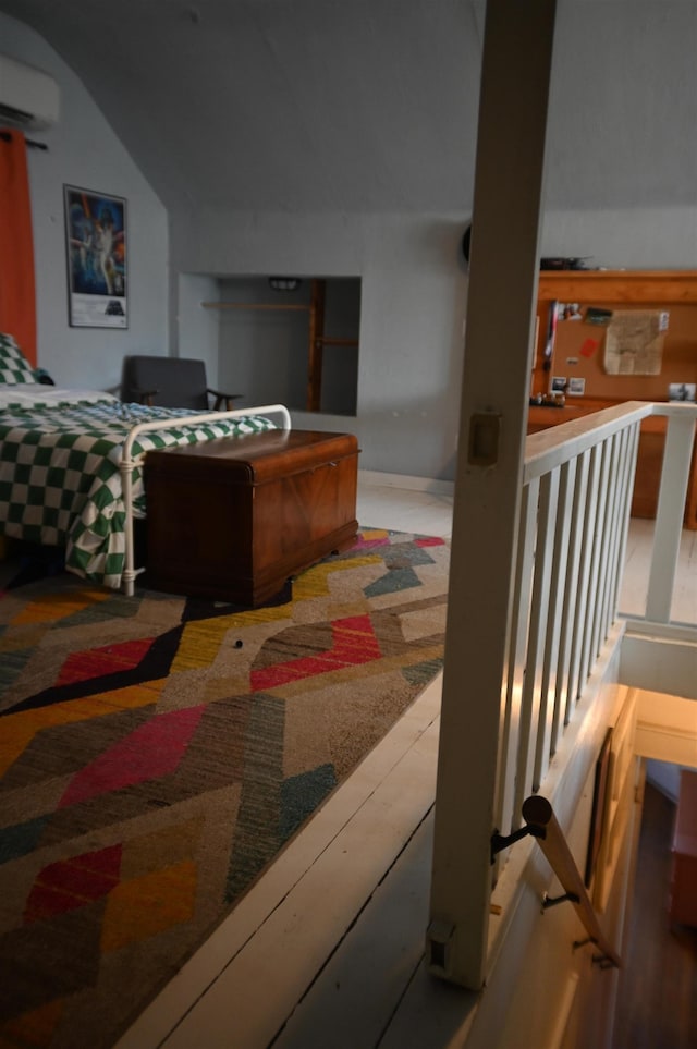 bedroom featuring a wall unit AC and lofted ceiling