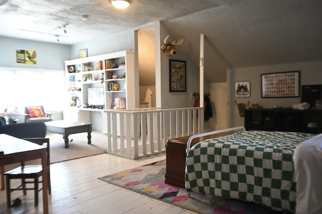 bedroom with light wood-type flooring and track lighting