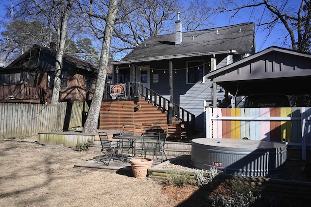 rear view of property with a patio and a hot tub