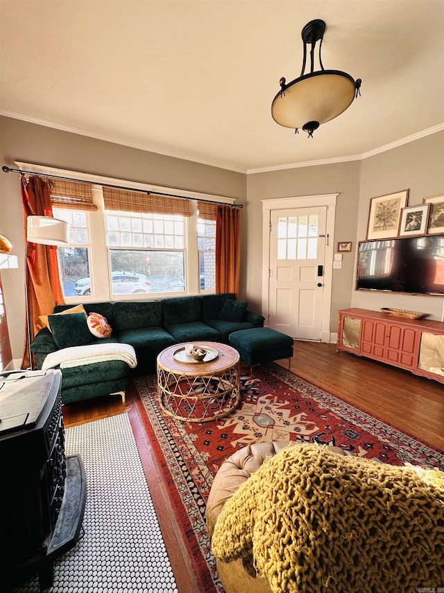 living room with wood-type flooring, a wood stove, and ornamental molding