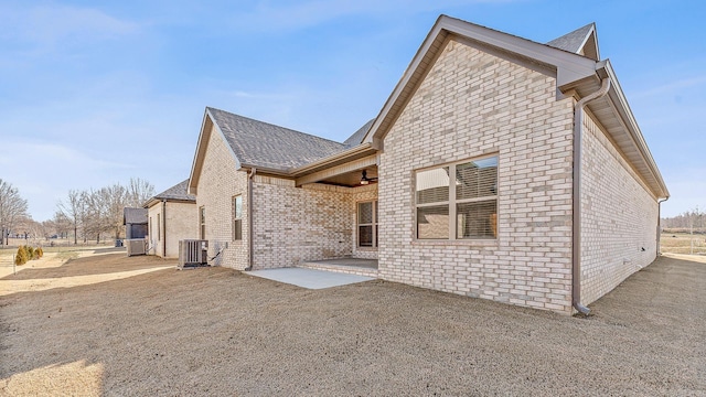 rear view of house with ceiling fan, cooling unit, and a patio area