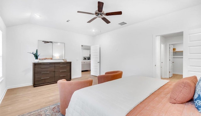 bedroom with vaulted ceiling, ceiling fan, a spacious closet, light hardwood / wood-style flooring, and a closet