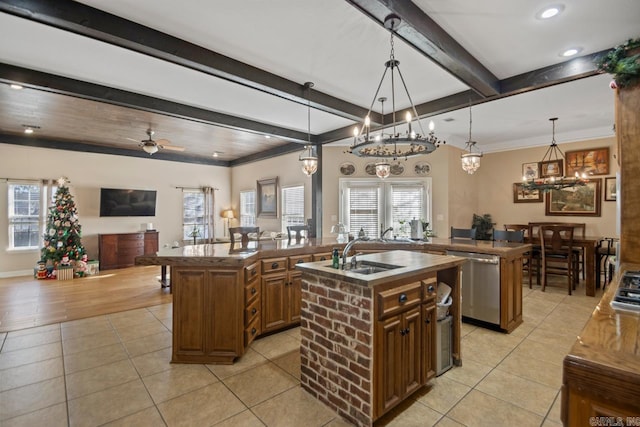 kitchen with sink, stainless steel dishwasher, pendant lighting, a kitchen island with sink, and ceiling fan with notable chandelier