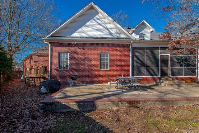 rear view of property featuring a sunroom and a patio