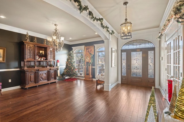 foyer entrance featuring a chandelier, dark hardwood / wood-style flooring, and ornamental molding