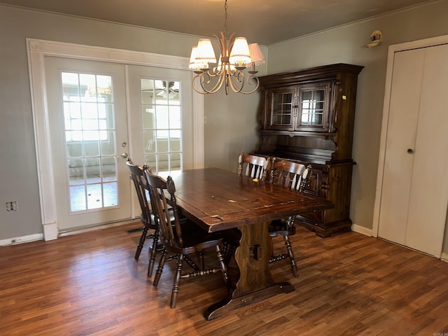 dining area with dark wood-type flooring, a healthy amount of sunlight, and an inviting chandelier