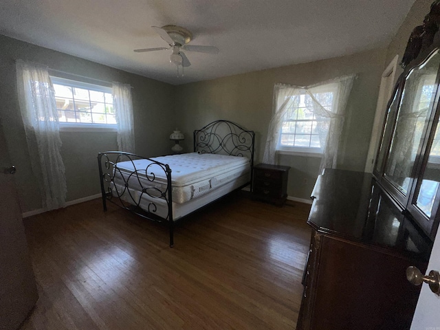 bedroom featuring multiple windows, ceiling fan, and dark hardwood / wood-style floors