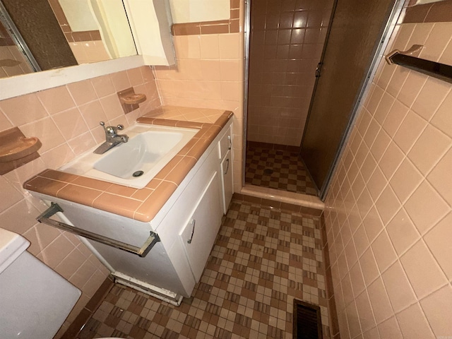 bathroom with backsplash, tile walls, an enclosed shower, and toilet