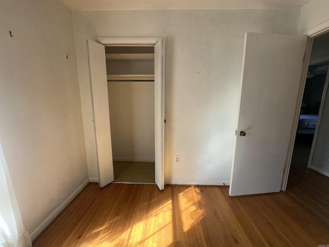 unfurnished bedroom with a closet and wood-type flooring