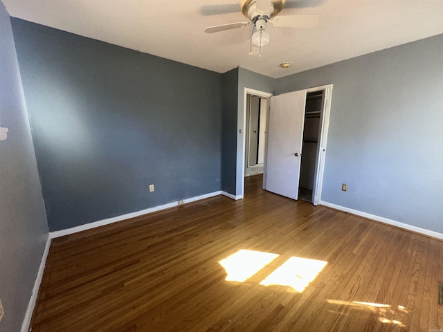 unfurnished bedroom featuring ceiling fan, dark hardwood / wood-style floors, and a closet