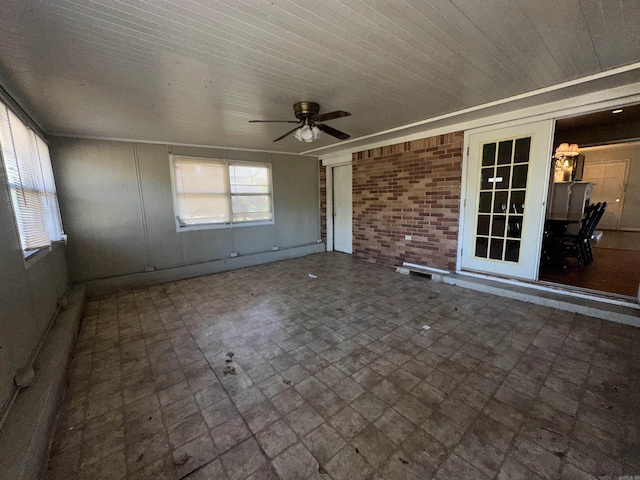 unfurnished sunroom with ceiling fan