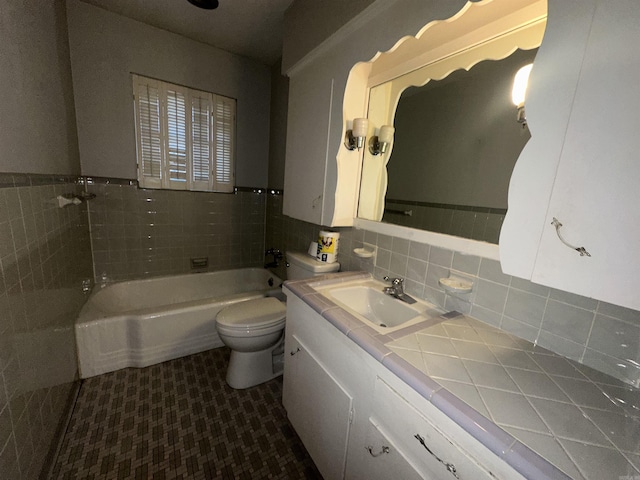 bathroom featuring a washtub, toilet, decorative backsplash, vanity, and tile walls