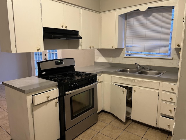 kitchen with light tile patterned floors, gas stove, white cabinetry, and sink