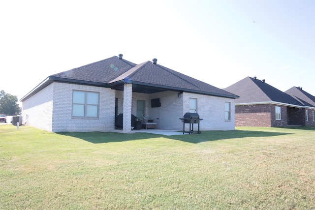 rear view of property featuring a yard and a patio area