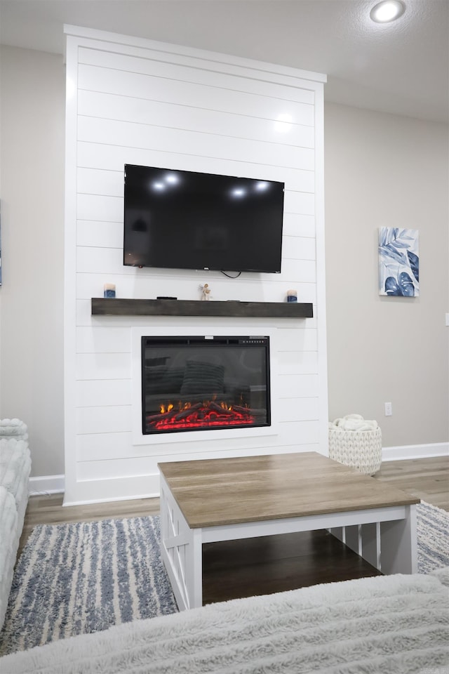 room details with a large fireplace, hardwood / wood-style floors, and a textured ceiling