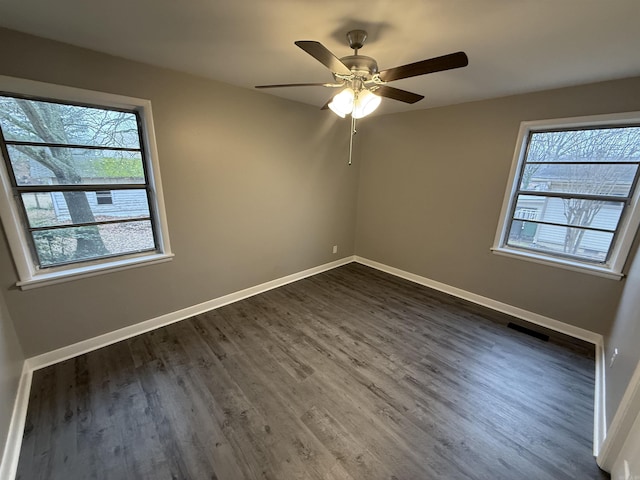 spare room featuring dark hardwood / wood-style flooring and ceiling fan