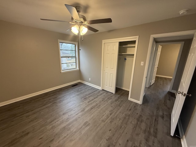 unfurnished bedroom featuring ceiling fan, dark hardwood / wood-style floors, and a closet