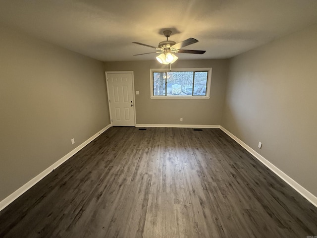 empty room featuring ceiling fan and dark wood-type flooring