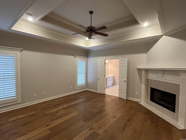 unfurnished living room with ceiling fan, a fireplace, and a tray ceiling