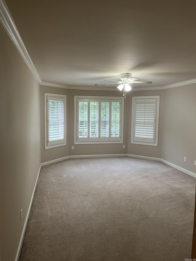 carpeted empty room with ceiling fan and crown molding